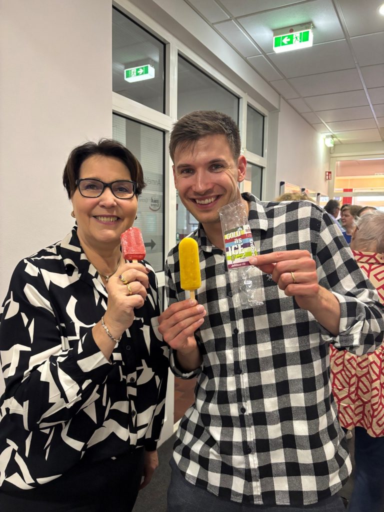 Zwei Mitarbeitende der Grone Wirtschaftsakademie lächeln glücklich in die Kamera mit dem Jubiläums-Eis in der Hand.