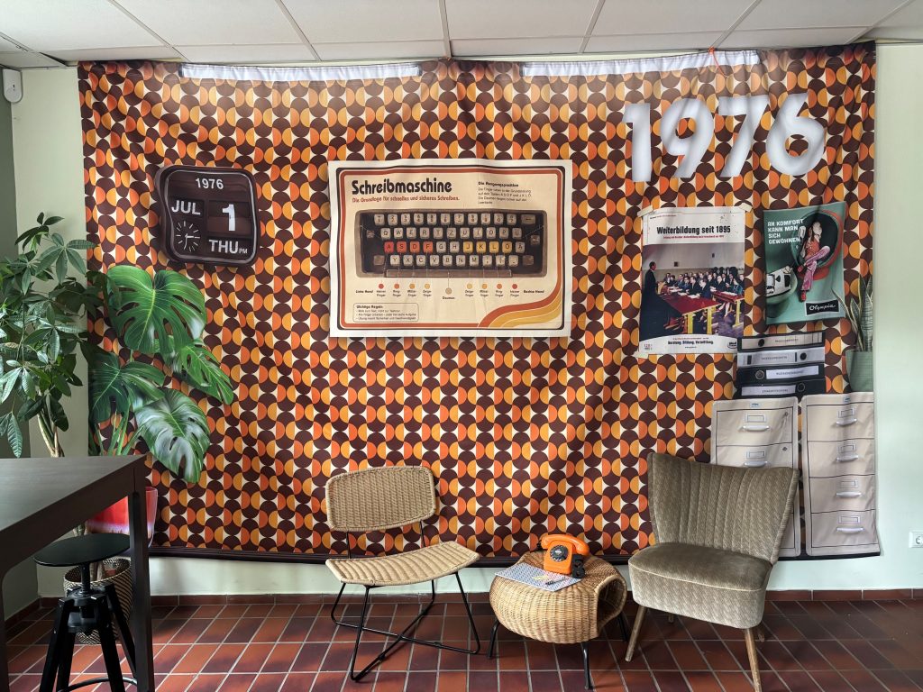 Das Foto zeigt eine dekorative Retro-Ecke aus den 70ern mit Wandtapete im Fleethaus in der Grone Wirtschaftsakademie.